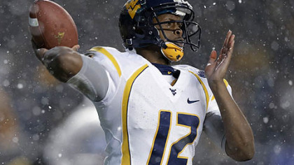 West Virginia quarterback Geno Smith passes in the snow against Syracuse during the second quarter of the Pinstripe Bowl.