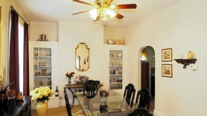 The dining room boasts built-in china cabinets and two tall windows.