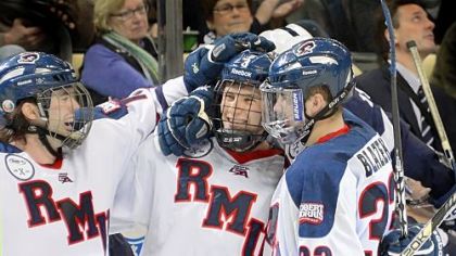 Robert Morris' Tyler Hinds, middle, is congratulated after scoring in the third period against Penn State in the Three Rivers Classic Friday at Consol Energy Center.