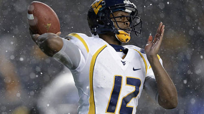 West Virginia quarterback Geno Smith passes in the snow against Syracuse in the second quarter of the Pinstripe Bowl.