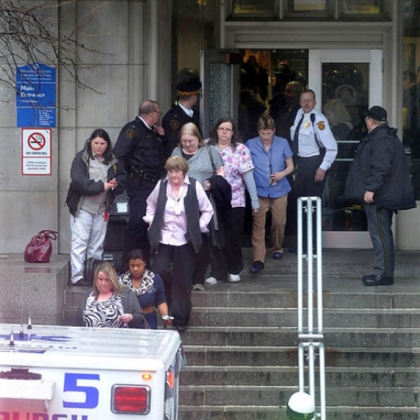 People evacuate Western Psychiatric Institute and Clinic in the Oakland section of Pittsburgh and are put into an ambulance and taken to a safe location.