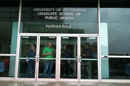 People watch police activity outside a Univeristy of Pittsburgh Graduate School of Public Healtyh building near the shooting scene at Western Psychiatric Institute and Clinic in Oakland this afternoon.