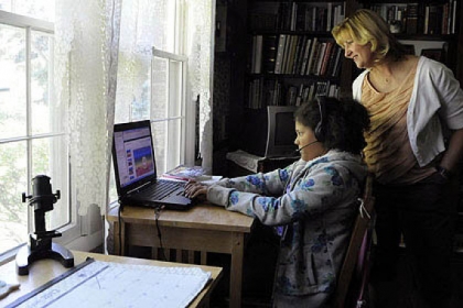 Jill Buffalini watches her daughter, Maria, 10, give her Power Point presentation to her social studies/science cyber class.