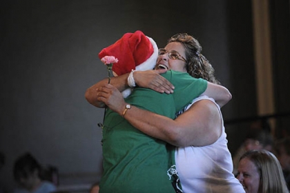 Marion Anderson, 15, of Newport News, Va., hugs Dolores Romanelli Wednesday night after presenting her with a carnation when it was announced that volunteers at the Pittsburgh Project would fix up Ms. Romanelli's Brighton Heights' home.