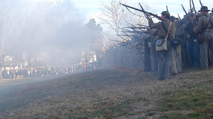 Confederate rifle men fire from behind a replica of the stone wall at the base of Marye's Heights, where the worst of the fighting occurred Dec 13, 1862, during the Battle of Fredericksburg, Va.