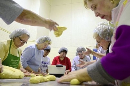 Volunteers from Holy Redeemer Parish in Ellwood City come together to roll dough that will be baked into Easter bread.