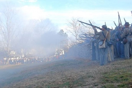 Confederate riflemen fire from behind a replica of the stone wall at the base of Marye's Heights, where the worst of the fighting occurred Dec. 13, 1862, during the Battle of Fredericksburg, Va.
